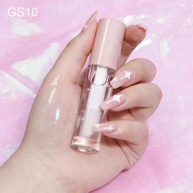 Pink lip oil in a clear tube held in a hand