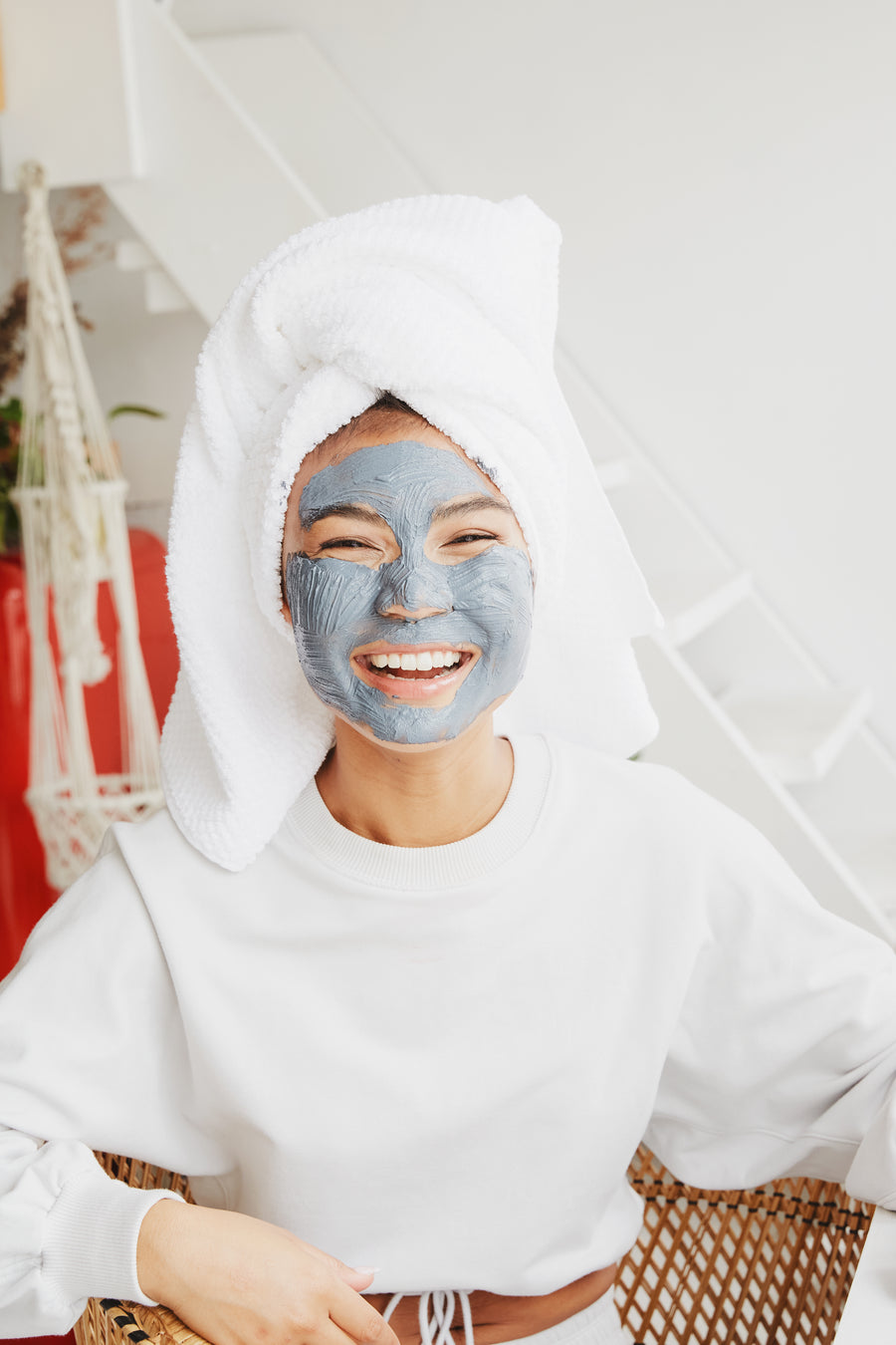 Woman with hair in a towel turban wearing a moisturizing sheet mask