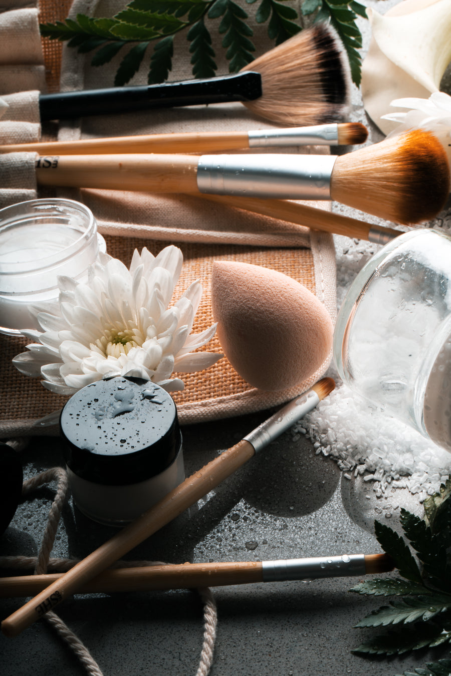 Skincare and beauty tools arranged with flowers on a styled surface