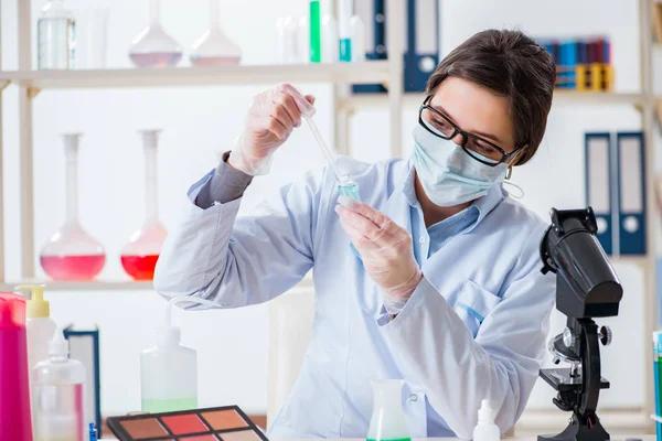 Laboratory technician inspecting cosmetic samples