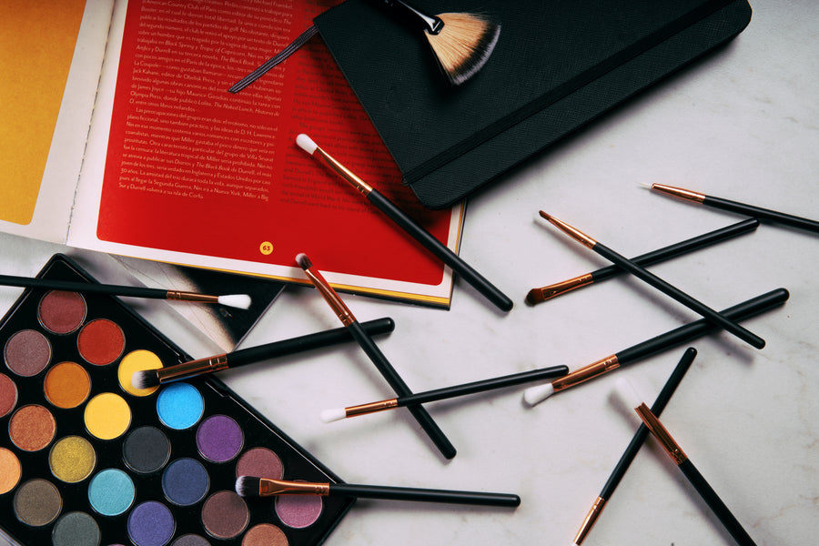 Colourful eyeshadow palette with makeup brushes on a styled surface
