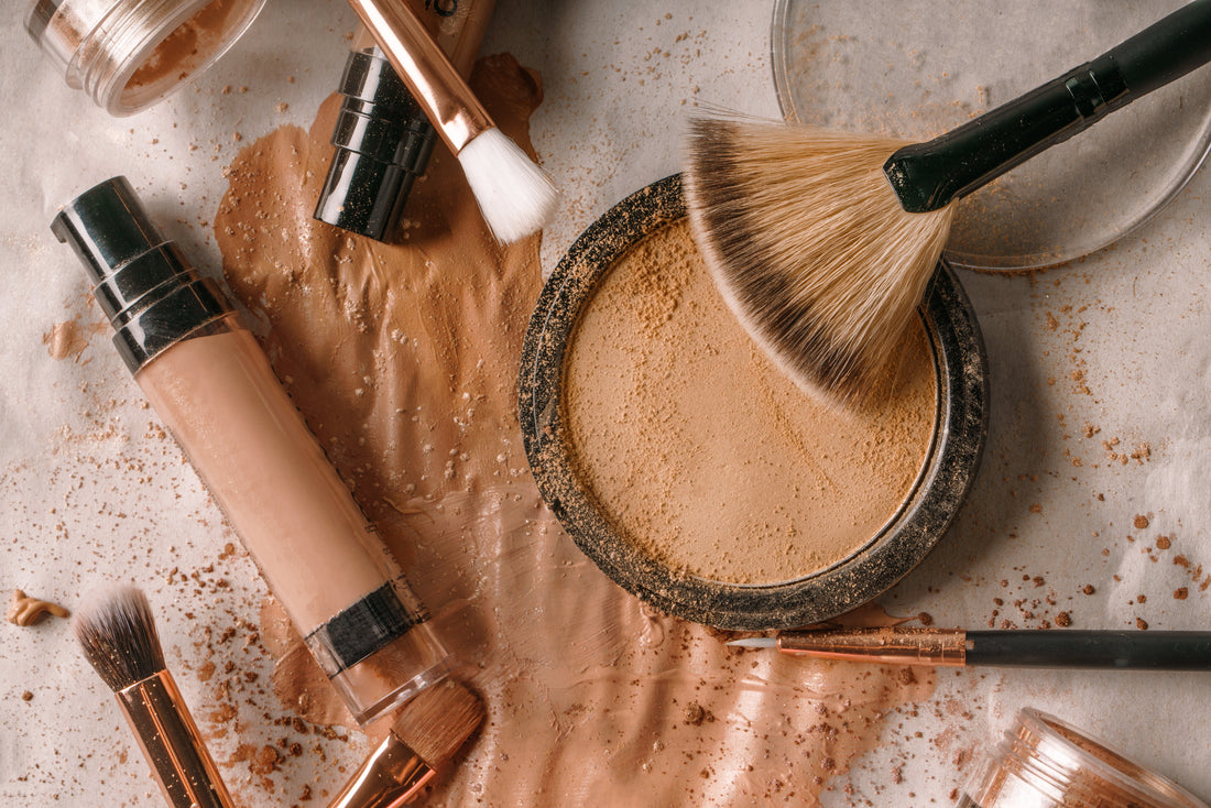 Face makeup with foundation, pressed powder and brushes