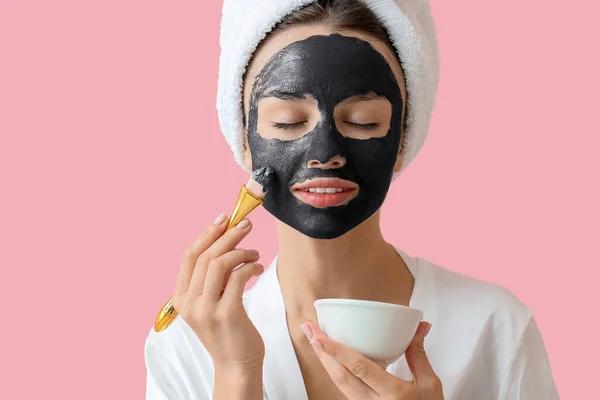 Activated charcoal peel-off mask being lifted from skin